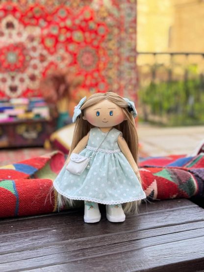 Игрушечная кукла в синем платье.